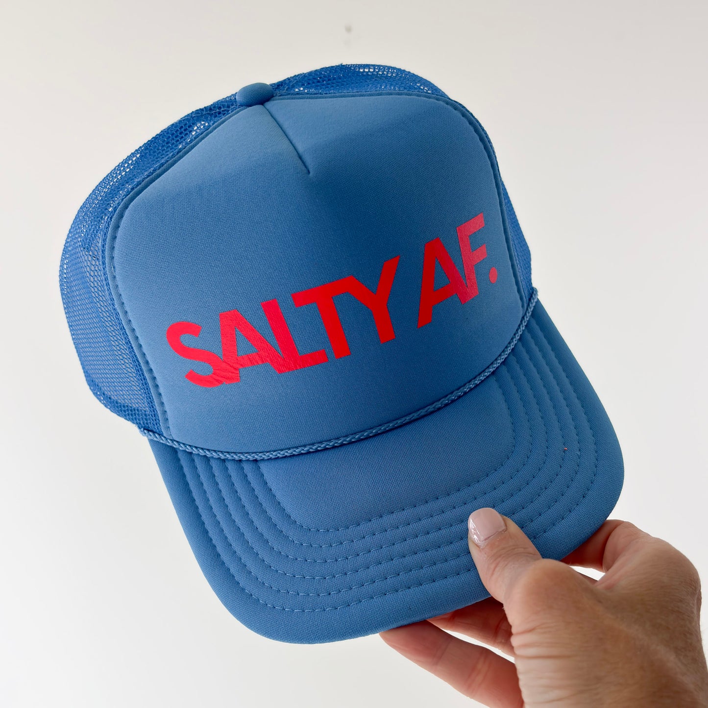 Women's bright blue high profile snap back foam trucker hat with neon coral "salty af." graphic
