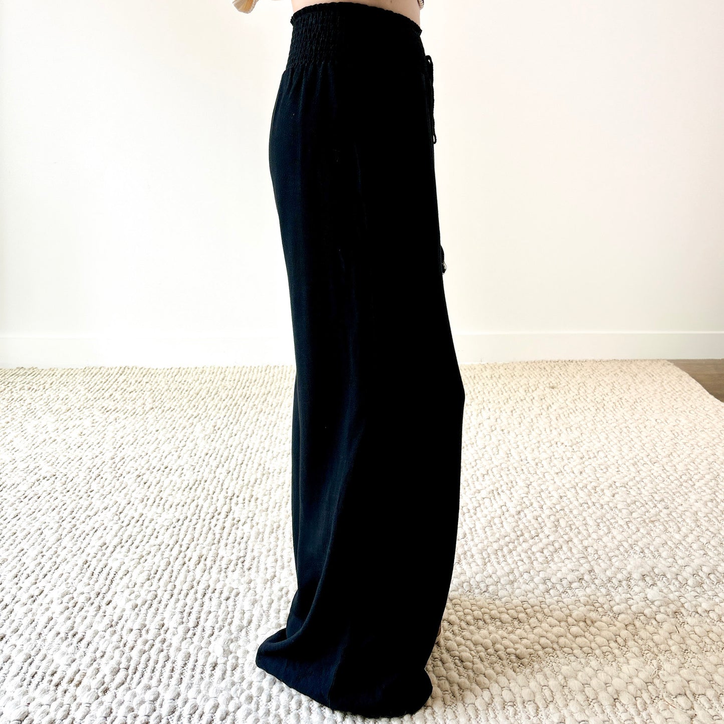 Women's black smocked waist wide leg pant with pockets and tassel drawcord