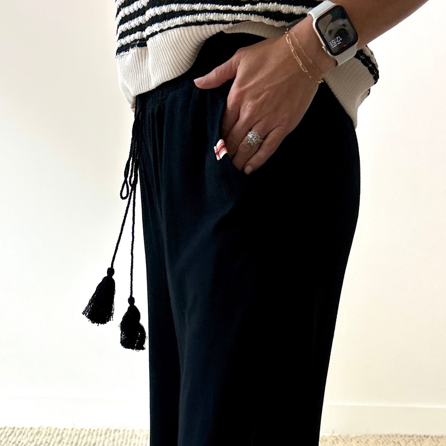 Women's black smocked waist wide leg pant with pockets and tassel drawcord