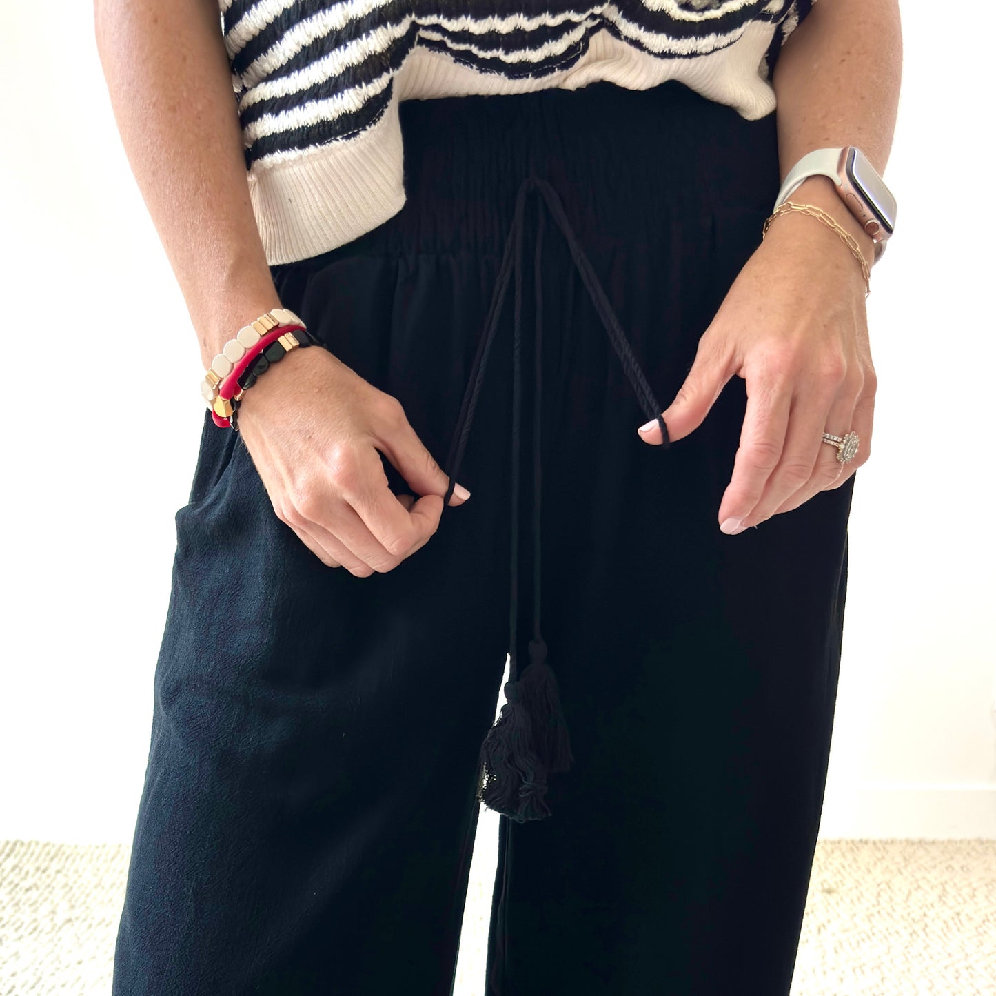 Women's black smocked waist wide leg pant with pockets and tassel drawcord