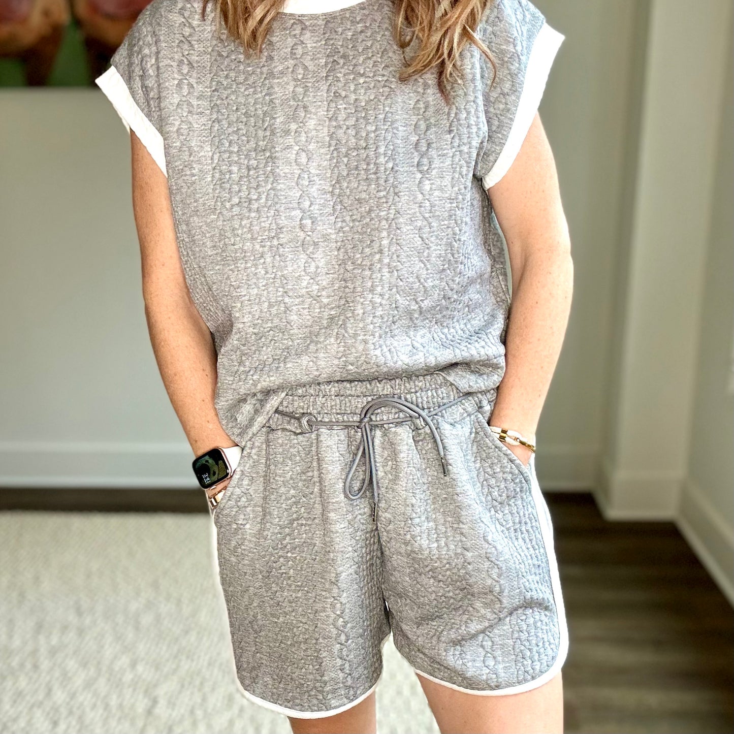 Heather grey cable knit textured pull on knit short with white tipping at curved hem. Side pockets.