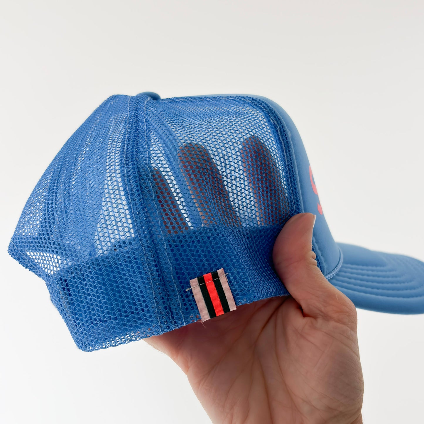 Women's bright blue high profile snap back foam trucker hat with neon coral "salty af." graphic