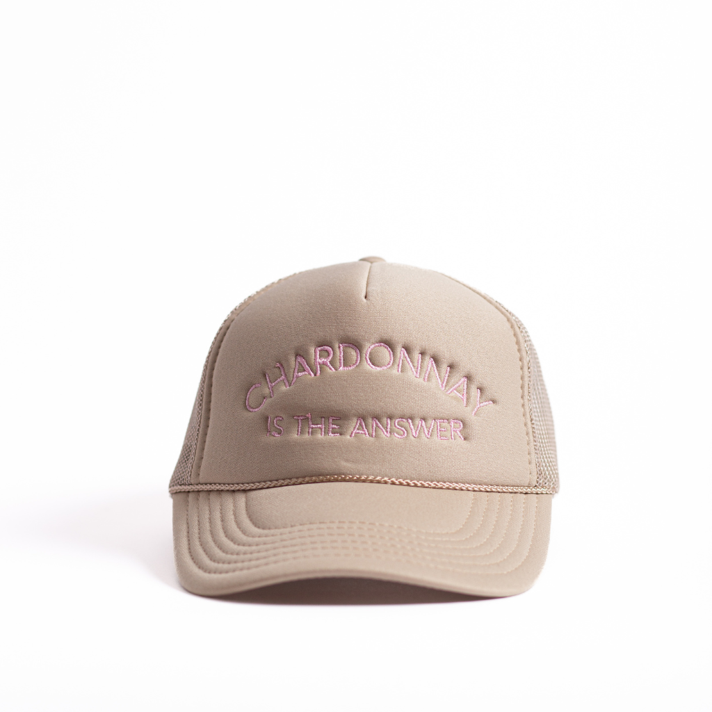 Tan mid profile trucker hat with light pink embroidered chardonnay is the answer