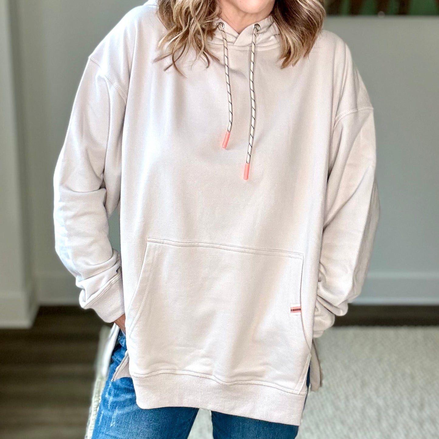 Light grey super soft hooded side zip pullover sweatshirt with front pocket and neon coral tipped drawcord Edit alt text