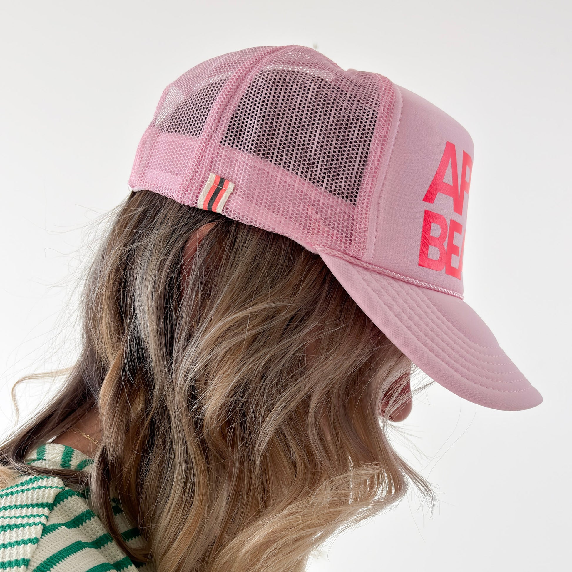 Women's light pink high profile trucker hat with neon coral après beach print