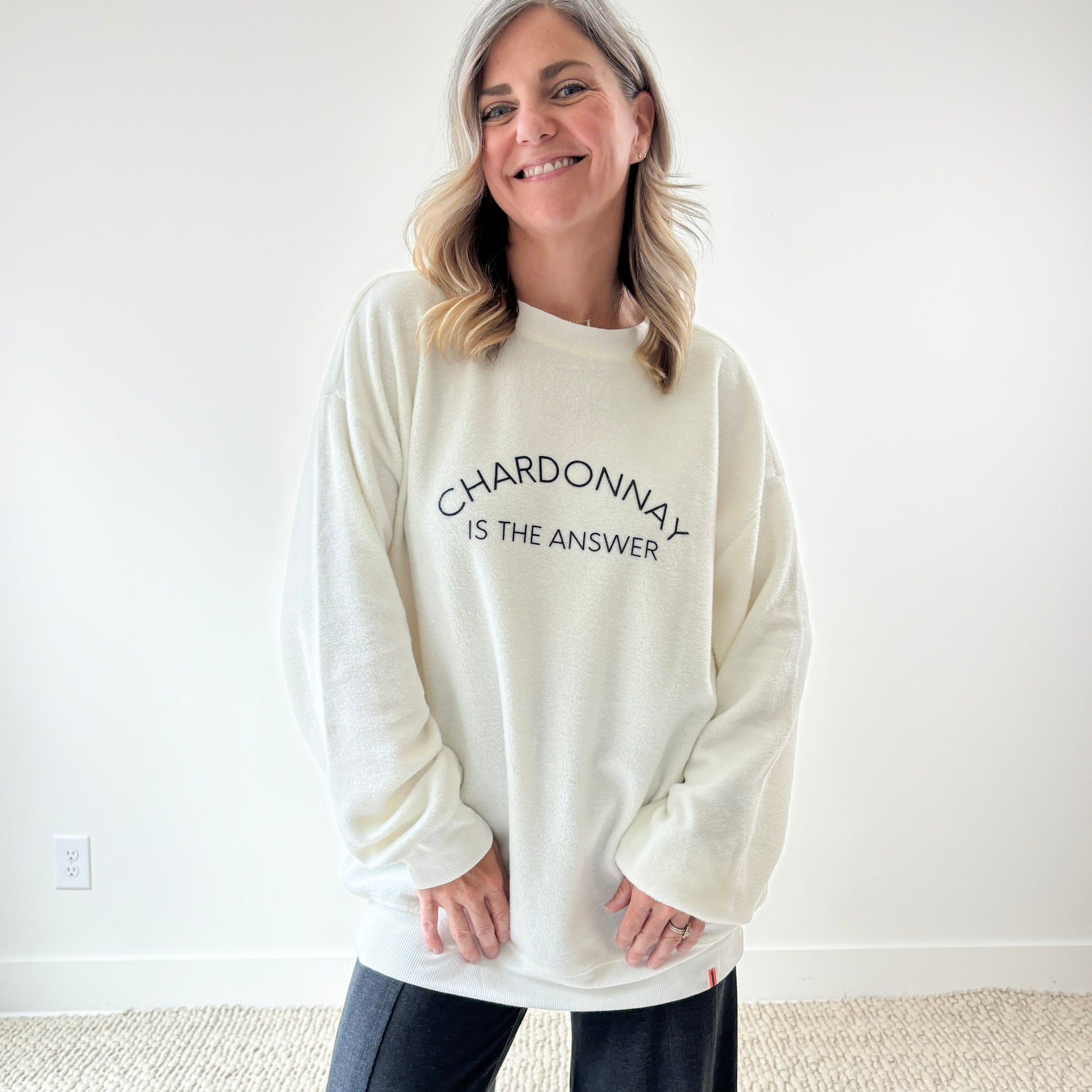 Women's ivory crewneck fuzzy tunic length sweatshirt with charcoal grey printed chardonnay is the answer graphic