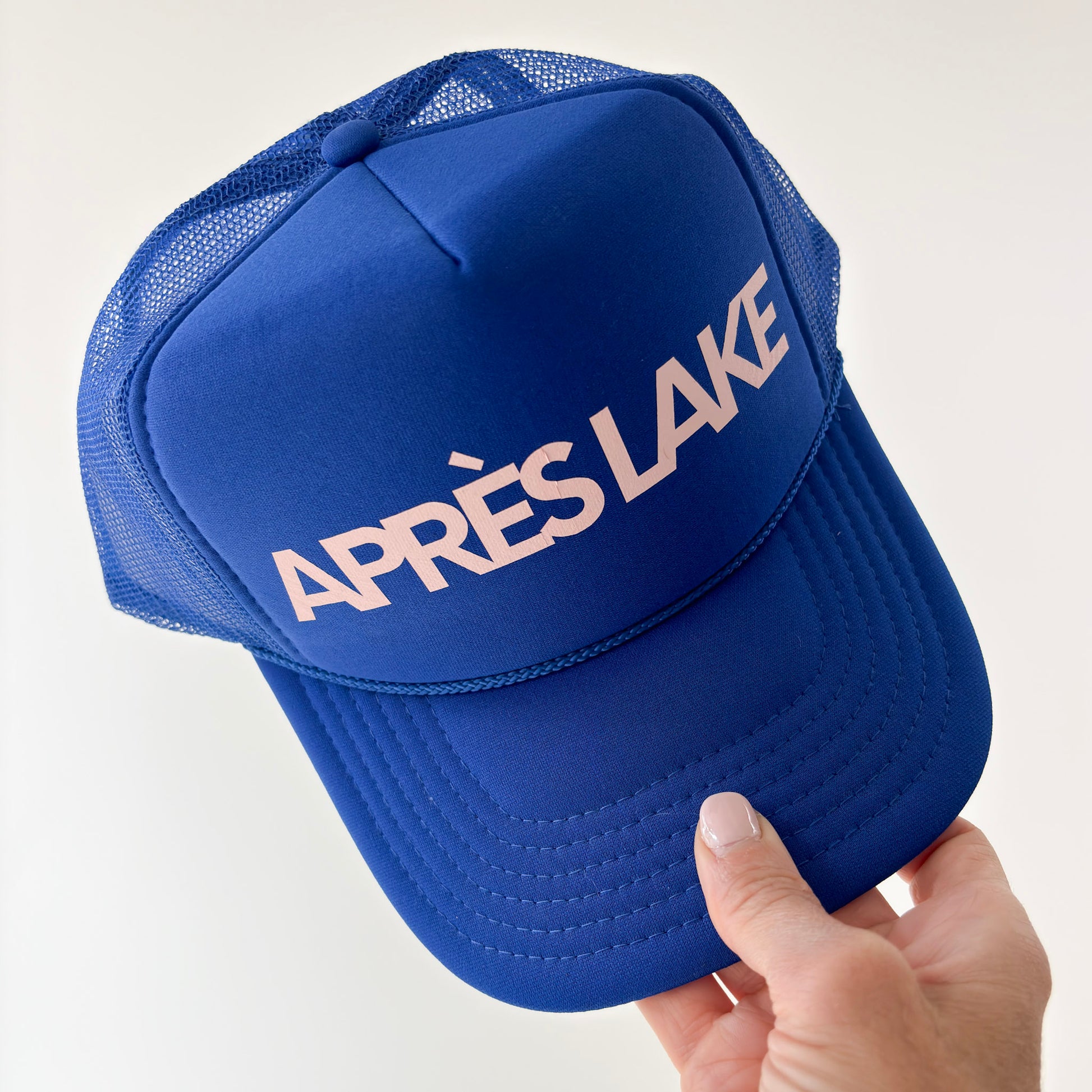 Women's high profile bright blue snap back trucker hat with light pink après lake graphic