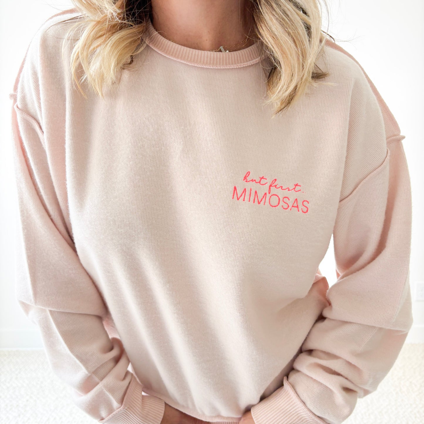 Women's light pink exposed seem crewneck sweatshirt with but first mimosas neon pink left chest embroidery
