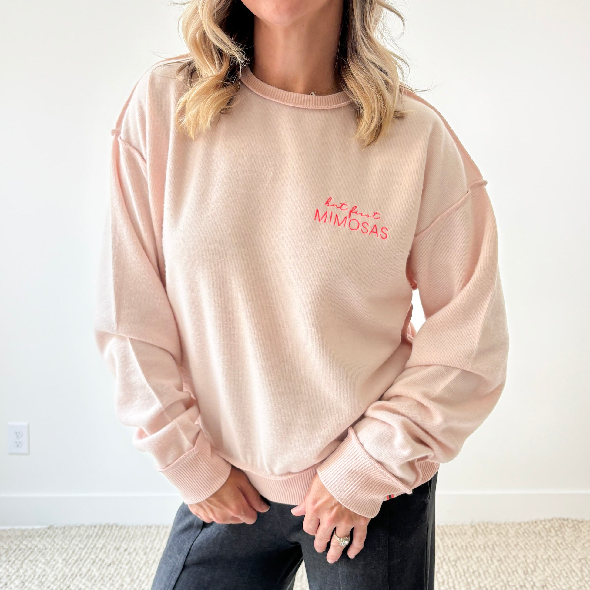Women's light pink exposed seem crewneck sweatshirt with but first mimosas neon pink left chest embroidery