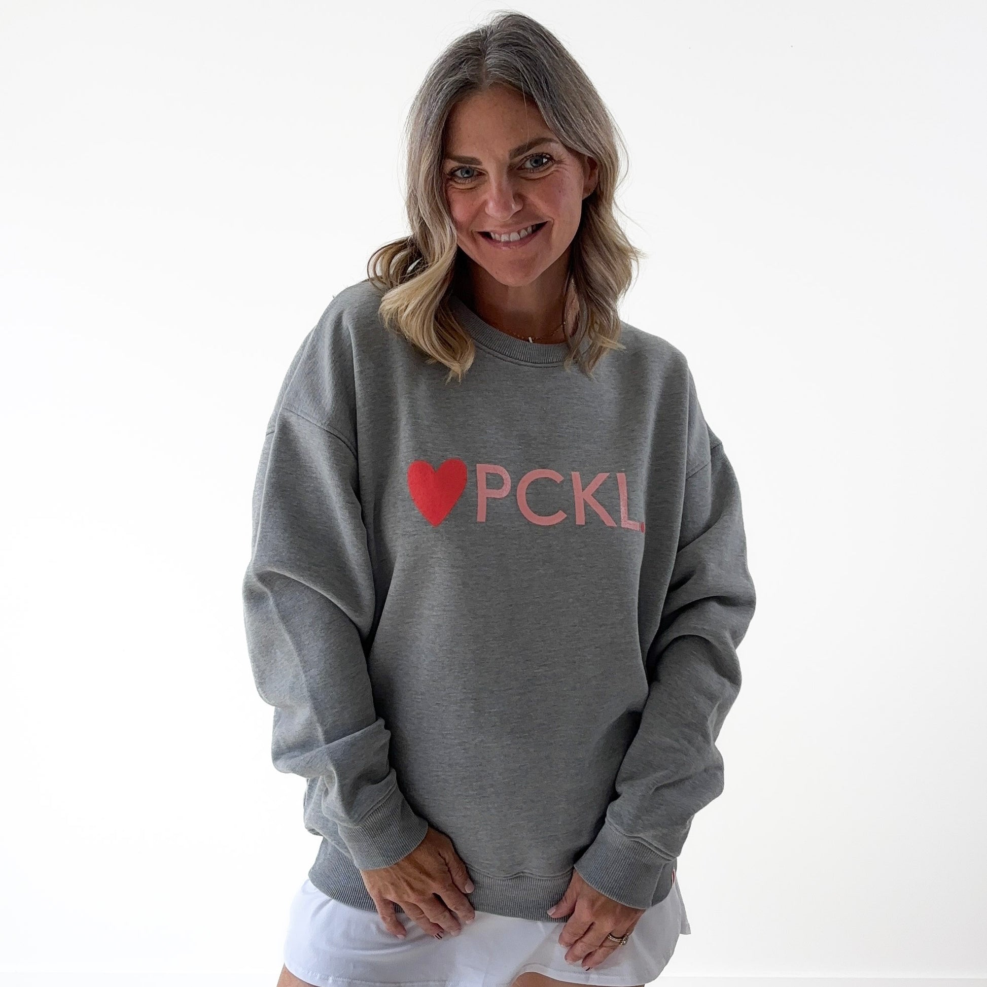Women's heather gray classic crewneck fleece sweatshirt with pink heart PCKL pickleball screenprint