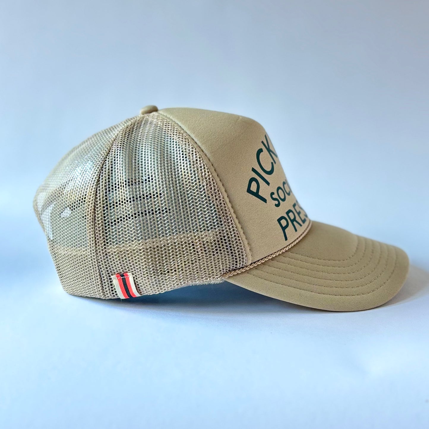 Tan mid profile trucker hat with dark green pickleball social club president print