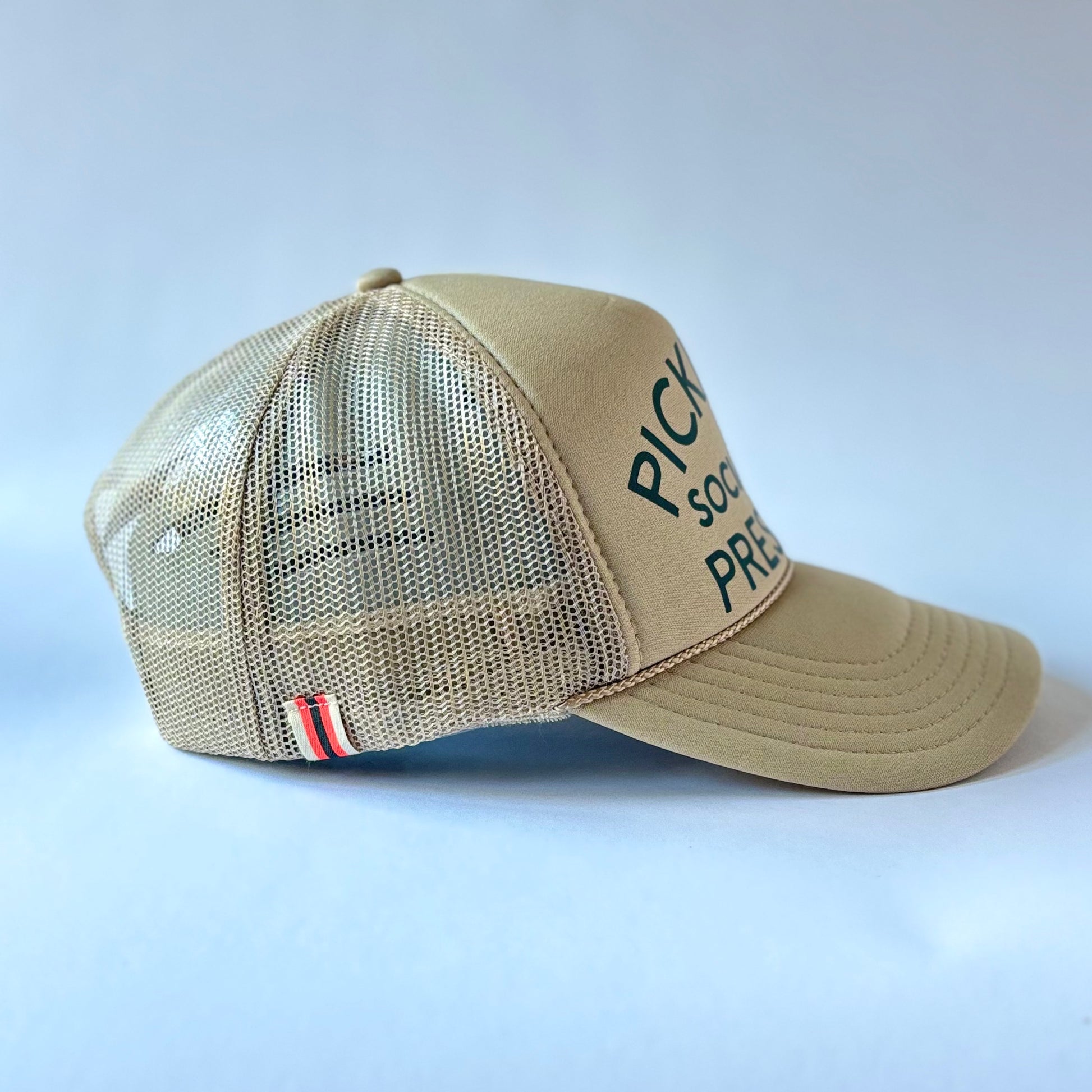 Tan mid profile trucker hat with dark green pickleball social club president print