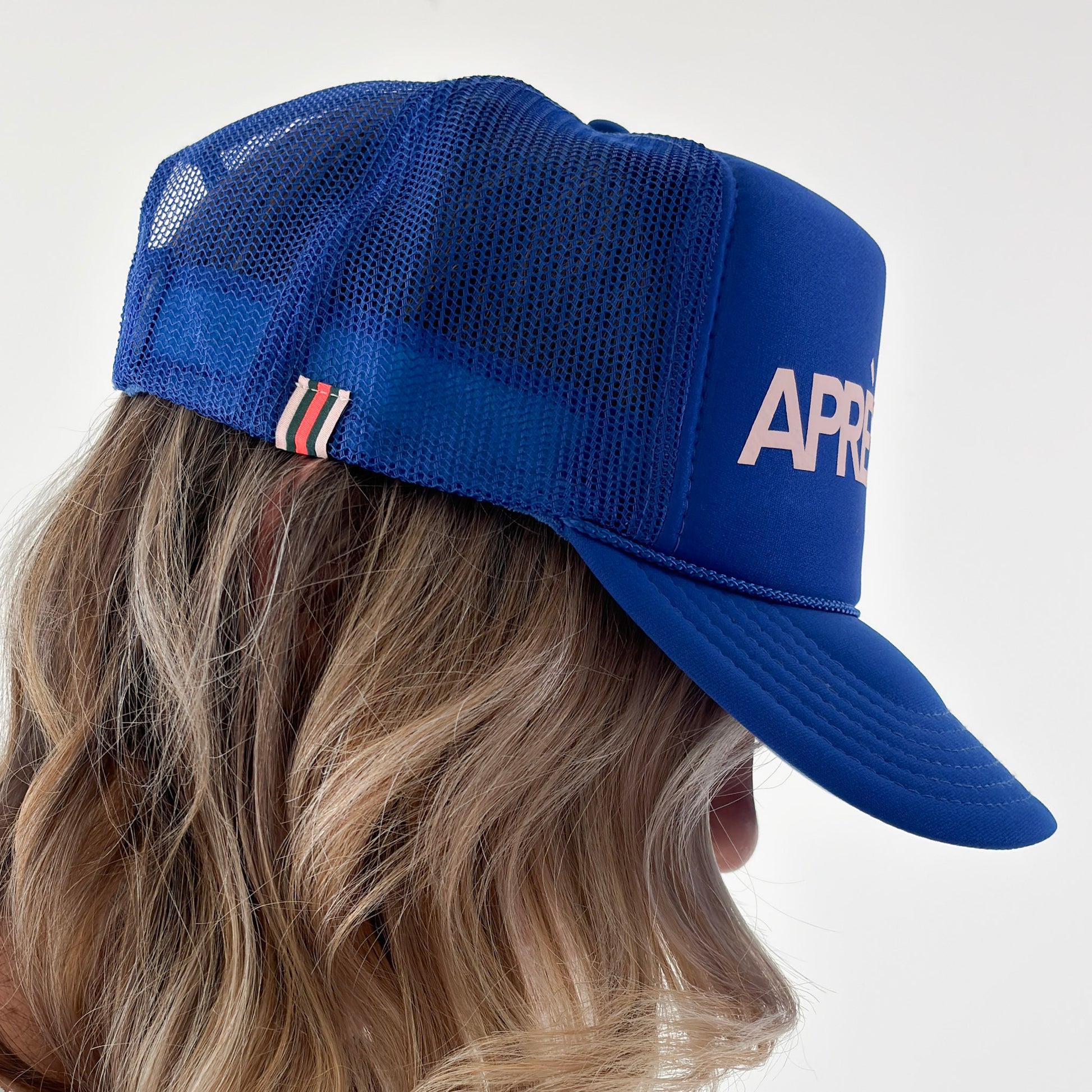 Women's high profile bright blue snap back trucker hat with light pink après lake graphic