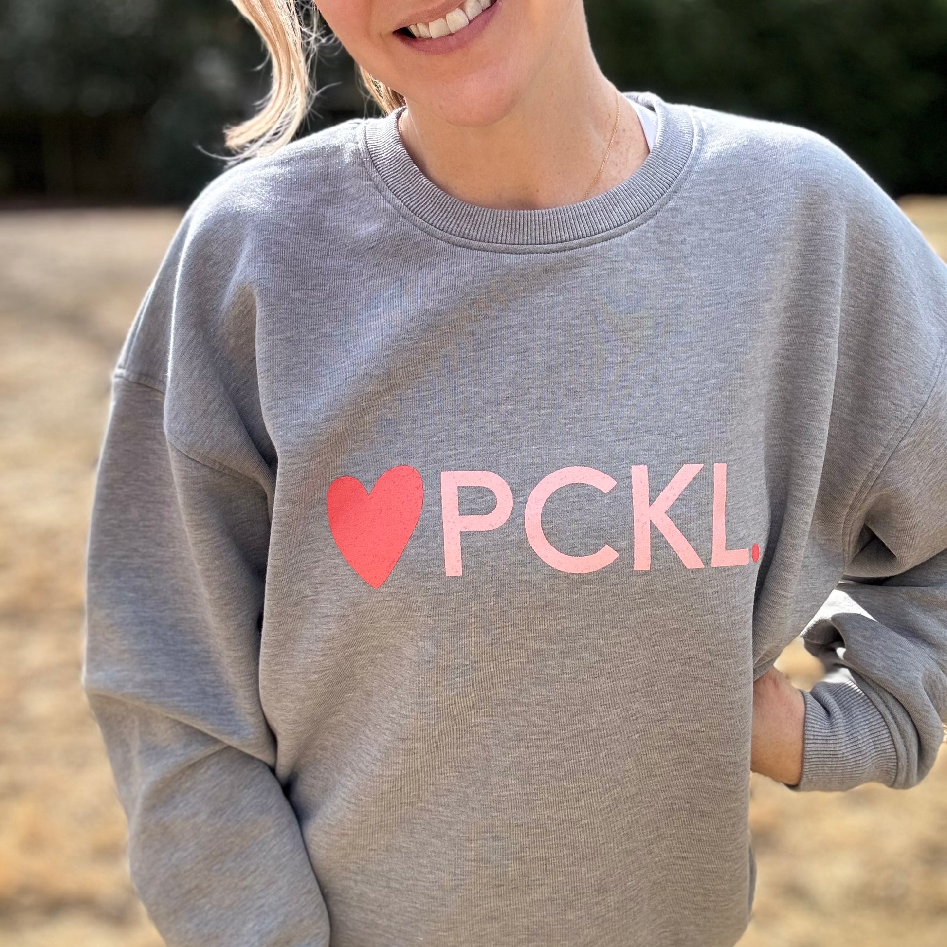 Women's heather gray classic crewneck fleece sweatshirt with pink heart PCKL pickleball screenprint