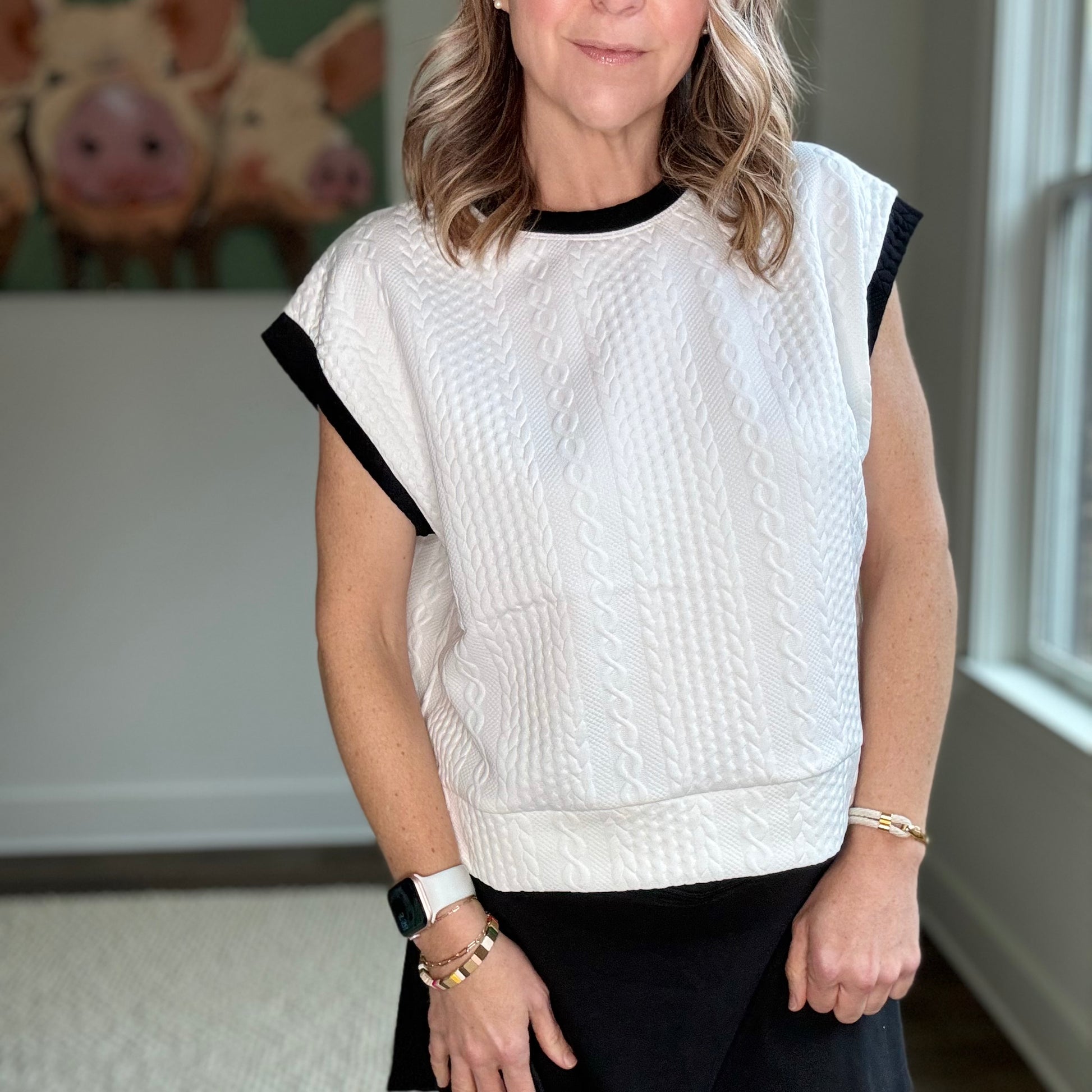 White cable knit textured cap sleeve top with black tipping at neck and armholes