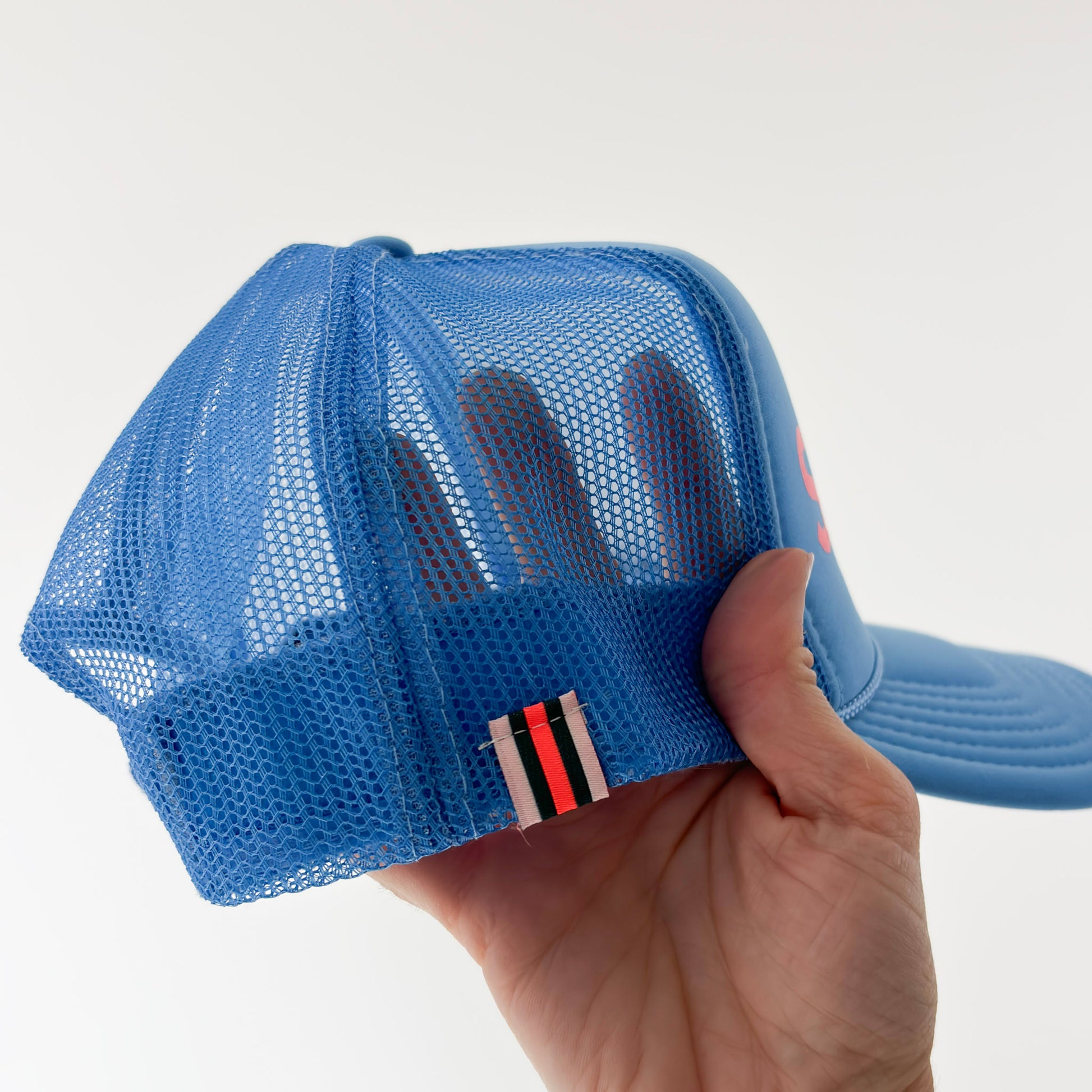Women's bright blue high profile snap back foam trucker hat with neon coral "salty af." graphic