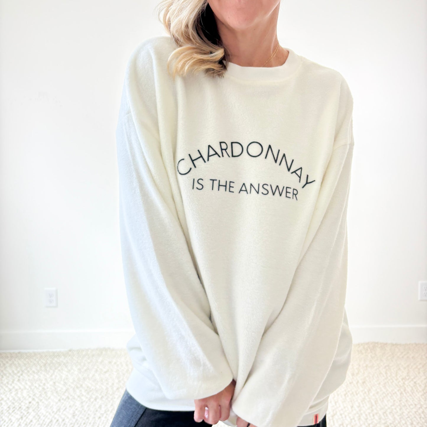Women's ivory crewneck fuzzy tunic length sweatshirt with charcoal grey printed chardonnay is the answer graphic