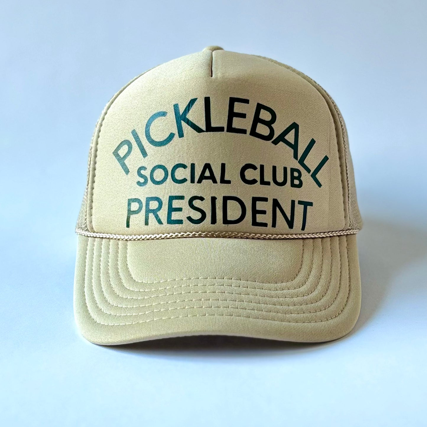 Tan mid profile trucker hat with dark green pickleball social club president print