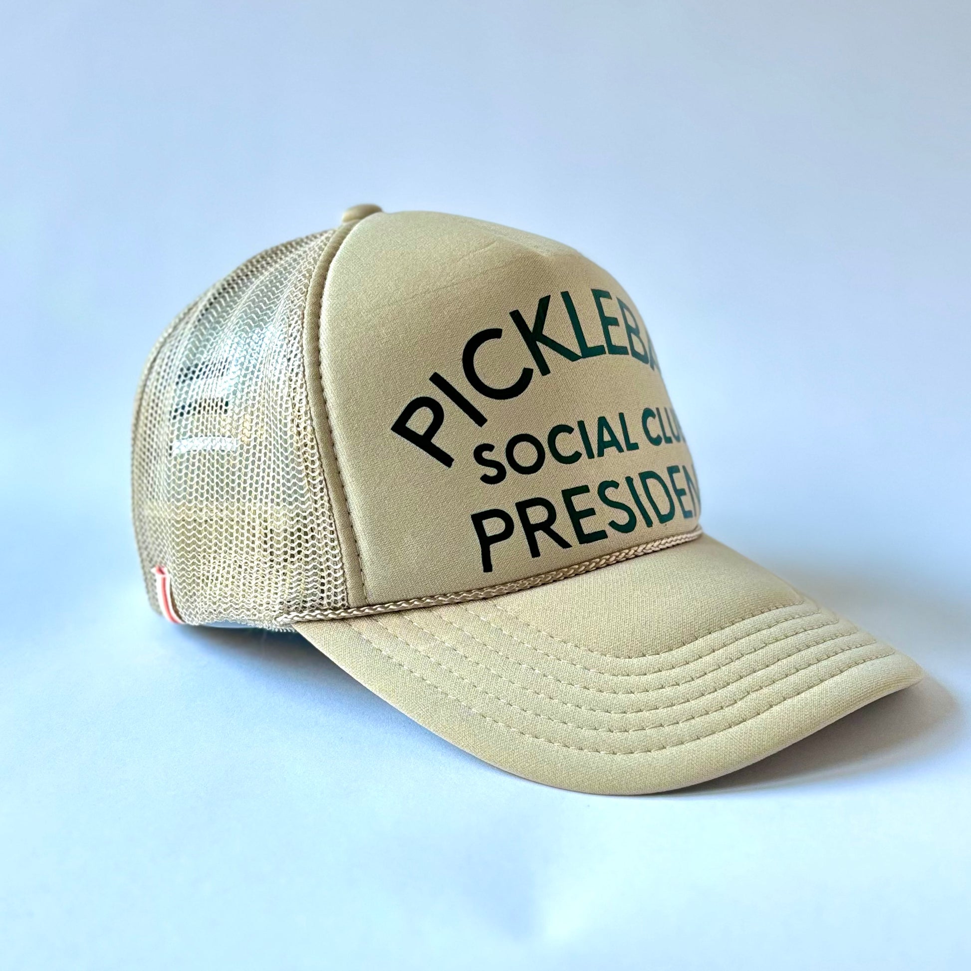 Tan mid profile trucker hat with dark green pickleball social club president print
